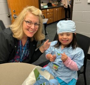 school nurse and a student dressed as doctor sharing smiles